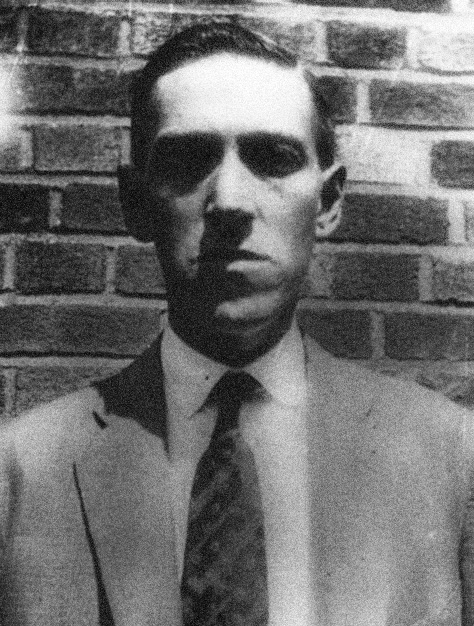 H. P. Lovecraft standing in front of a brick wall